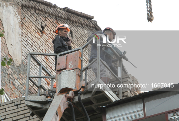 Workers are at a pile of rubble at the apartment block in Vokzalna Square that is being dismantled in Dnipro, Ukraine, on October 14, 2024....