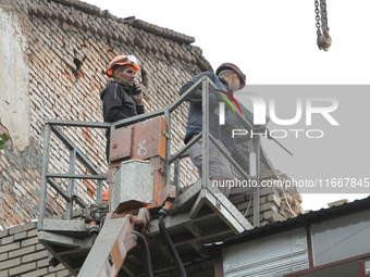 Workers are at a pile of rubble at the apartment block in Vokzalna Square that is being dismantled in Dnipro, Ukraine, on October 14, 2024....