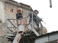 Workers are at a pile of rubble at the apartment block in Vokzalna Square that is being dismantled in Dnipro, Ukraine, on October 14, 2024....