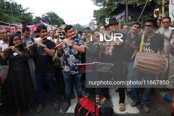 Protesters play the flutes while doctors and citizens shout slogans during a protest carnival, the ''Droho carnival'', demanding India's Wes...