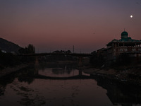 The moon appears over a mosque in Baramulla, Jammu and Kashmir, India, on October 15, 2024. (