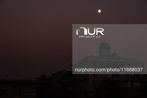 The moon appears over a mosque in Baramulla, Jammu and Kashmir, India, on October 15, 2024. 