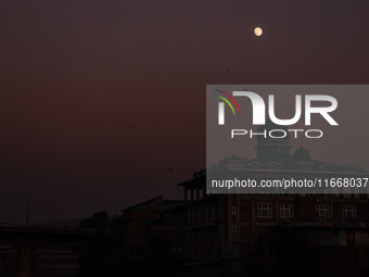 The moon appears over a mosque in Baramulla, Jammu and Kashmir, India, on October 15, 2024. (