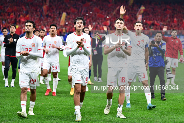 Indonesia players greet during the Chinese football team's match against Indonesia in the 4th round of the World Qualifiers Asian Zone in Qi...