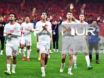 Indonesia players greet during the Chinese football team's match against Indonesia in the 4th round of the World Qualifiers Asian Zone in Qi...