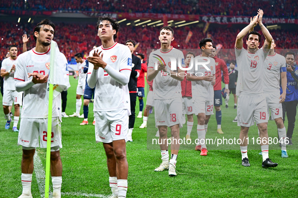 Indonesia players greet during the Chinese football team's match against Indonesia in the 4th round of the World Qualifiers Asian Zone in Qi...