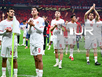 Indonesia players greet during the Chinese football team's match against Indonesia in the 4th round of the World Qualifiers Asian Zone in Qi...