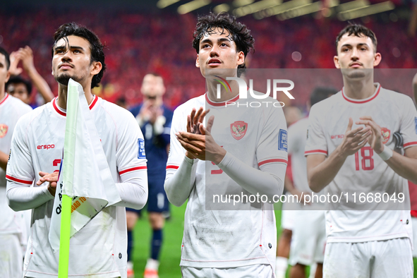 Indonesia players greet during the Chinese football team's match against Indonesia in the 4th round of the World Qualifiers Asian Zone in Qi...