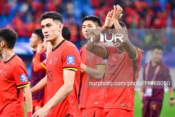 Chinese players greet during the Chinese football team's match against Indonesia in the 4th round of the World Qualifiers Asian Zone in Qing...