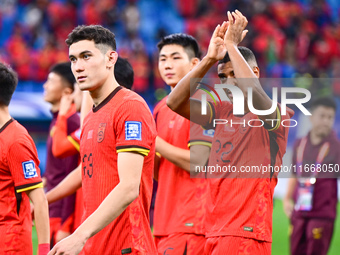 Chinese players greet during the Chinese football team's match against Indonesia in the 4th round of the World Qualifiers Asian Zone in Qing...