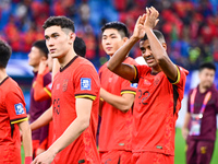 Chinese players greet during the Chinese football team's match against Indonesia in the 4th round of the World Qualifiers Asian Zone in Qing...