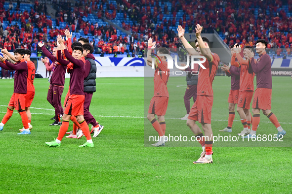 Chinese players greet during the Chinese football team's match against Indonesia in the 4th round of the World Qualifiers Asian Zone in Qing...