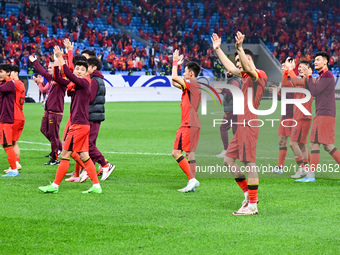 Chinese players greet during the Chinese football team's match against Indonesia in the 4th round of the World Qualifiers Asian Zone in Qing...