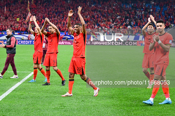 Chinese players greet during the Chinese football team's match against Indonesia in the 4th round of the World Qualifiers Asian Zone in Qing...