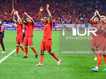 Chinese players greet during the Chinese football team's match against Indonesia in the 4th round of the World Qualifiers Asian Zone in Qing...