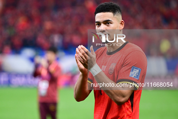 Chinese players greet during the Chinese football team's match against Indonesia in the 4th round of the World Qualifiers Asian Zone in Qing...