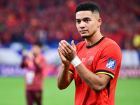 Chinese players greet during the Chinese football team's match against Indonesia in the 4th round of the World Qualifiers Asian Zone in Qing...