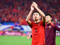 Chinese players greet during the Chinese football team's match against Indonesia in the 4th round of the World Qualifiers Asian Zone in Qing...