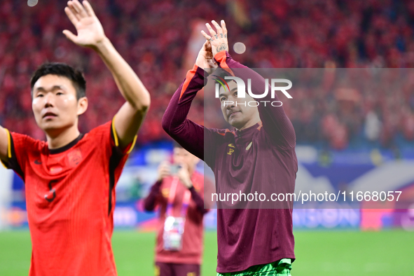 Chinese players greet during the Chinese football team's match against Indonesia in the 4th round of the World Qualifiers Asian Zone in Qing...