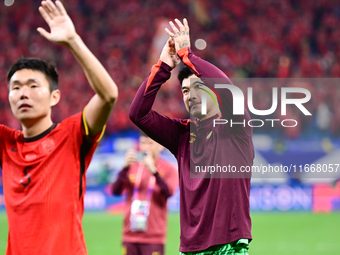 Chinese players greet during the Chinese football team's match against Indonesia in the 4th round of the World Qualifiers Asian Zone in Qing...