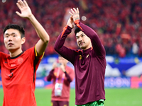 Chinese players greet during the Chinese football team's match against Indonesia in the 4th round of the World Qualifiers Asian Zone in Qing...