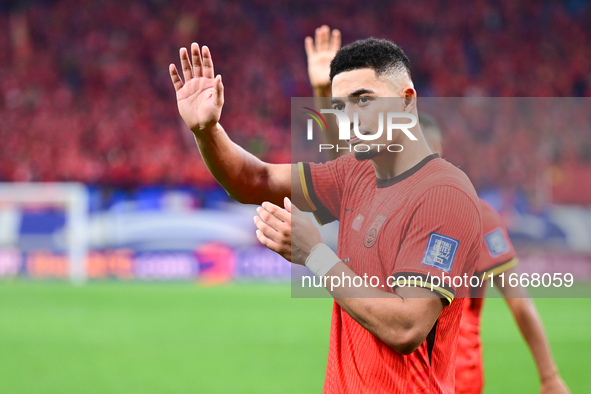 Chinese players greet during the Chinese football team's match against Indonesia in the 4th round of the World Qualifiers Asian Zone in Qing...