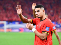 Chinese players greet during the Chinese football team's match against Indonesia in the 4th round of the World Qualifiers Asian Zone in Qing...