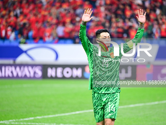 Chinese players greet during the Chinese football team's match against Indonesia in the 4th round of the World Qualifiers Asian Zone in Qing...