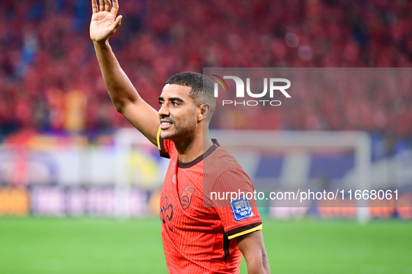 Chinese players greet during the Chinese football team's match against Indonesia in the 4th round of the World Qualifiers Asian Zone in Qing...