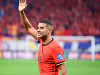 Chinese players greet during the Chinese football team's match against Indonesia in the 4th round of the World Qualifiers Asian Zone in Qing...