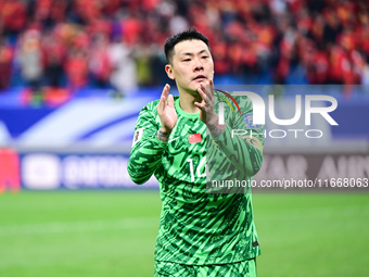 Chinese players greet during the Chinese football team's match against Indonesia in the 4th round of the World Qualifiers Asian Zone in Qing...