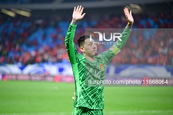 Chinese players greet during the Chinese football team's match against Indonesia in the 4th round of the World Qualifiers Asian Zone in Qing...