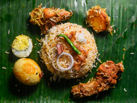 A pot of biryani, with aromatic basmati rice, cooked chicken, and a variety of spices such as saffron, kewra water, and fried onions known a...