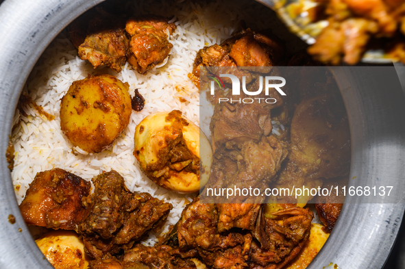 A pot of biryani, with aromatic basmati rice, cooked chicken, and a variety of spices such as saffron, kewra water, and fried onions known a...