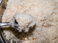 A pot of biryani, with aromatic basmati rice, cooked chicken, and a variety of spices such as saffron, kewra water, and fried onions known a...