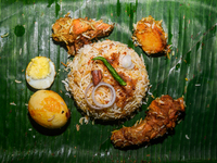 A pot of biryani, with aromatic basmati rice, cooked chicken, and a variety of spices such as saffron, kewra water, and fried onions known a...