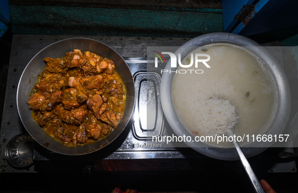 A pot of biryani, with aromatic basmati rice, cooked chicken, and a variety of spices such as saffron, kewra water, and fried onions known a...