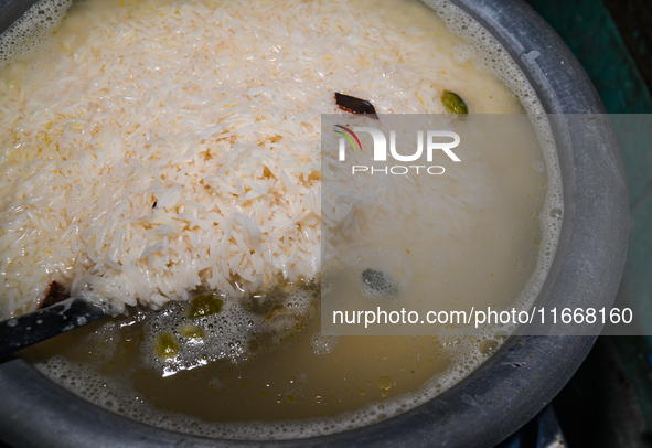 A pot of biryani, with aromatic basmati rice, cooked chicken, and a variety of spices such as saffron, kewra water, and fried onions known a...