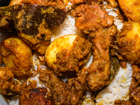 A pot of biryani, with aromatic basmati rice, cooked chicken, and a variety of spices such as saffron, kewra water, and fried onions known a...