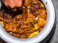 A pot of biryani, with aromatic basmati rice, cooked chicken, and a variety of spices such as saffron, kewra water, and fried onions known a...