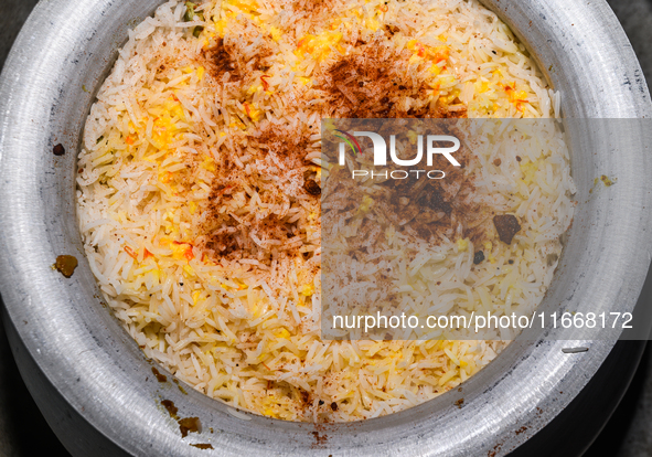 A pot of biryani, with aromatic basmati rice, cooked chicken, and a variety of spices such as saffron, kewra water, and fried onions known a...