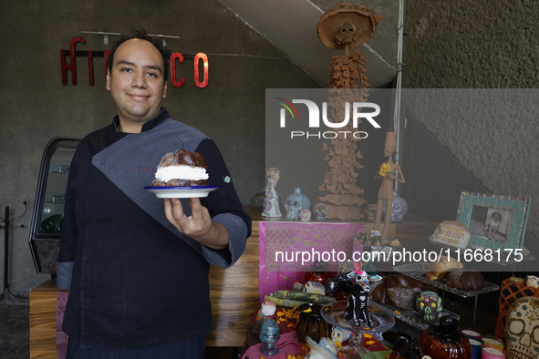 A chef holds a Pan de Muerto in front of an offering in Mexico City, Mexico, on the eve of the Day of the Dead. According to historical docu...