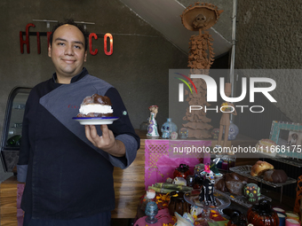 A chef holds a Pan de Muerto in front of an offering in Mexico City, Mexico, on the eve of the Day of the Dead. According to historical docu...