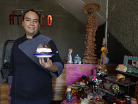 A chef holds a Pan de Muerto in front of an offering in Mexico City, Mexico, on the eve of the Day of the Dead. According to historical docu...