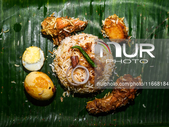 A pot of biryani, with aromatic basmati rice, cooked chicken, and a variety of spices such as saffron, kewra water, and fried onions known a...