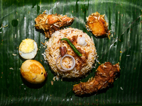 A pot of biryani, with aromatic basmati rice, cooked chicken, and a variety of spices such as saffron, kewra water, and fried onions known a...