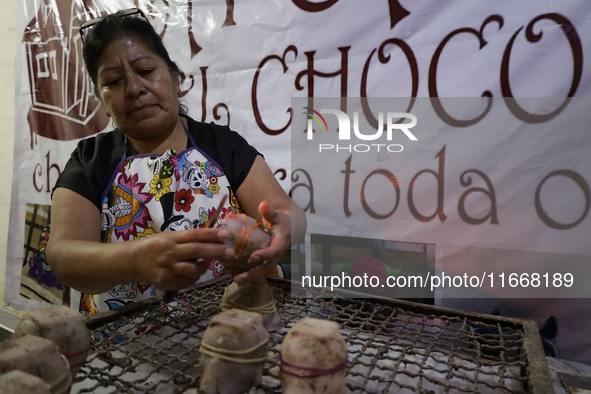 A woman manipulates molds to make chocolate skulls for sale in Mexico City, Mexico, on the eve of Day of the Dead. Sugar skulls are made fro...