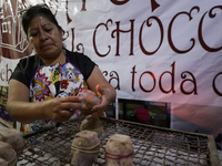 A woman manipulates molds to make chocolate skulls for sale in Mexico City, Mexico, on the eve of Day of the Dead. Sugar skulls are made fro...