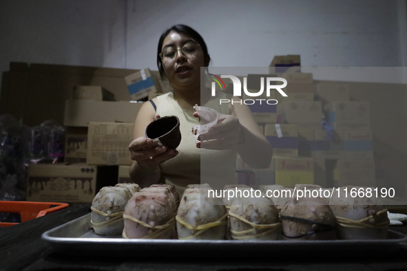 A woman manipulates molds to make chocolate skulls for sale in Mexico City, Mexico, on the eve of Day of the Dead. Sugar skulls are made fro...