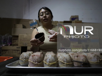 A woman manipulates molds to make chocolate skulls for sale in Mexico City, Mexico, on the eve of Day of the Dead. Sugar skulls are made fro...